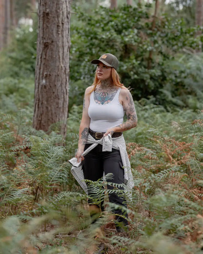 Tattooed woman in forest ladies outdoor stretch trousers for adventure and style