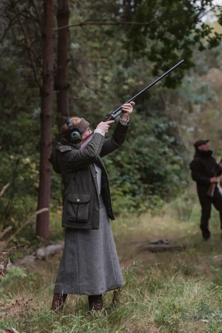 Lady in hunting gear aiming with ear protection wearing the forest ladies robyn jacket