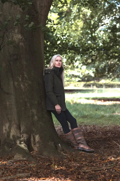 Woman in dark green Forest Ladies Robyn Jacket with black pants and striped boots