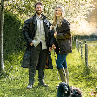 Couple in a traditional wax jacket with their dog enjoying the outdoors together