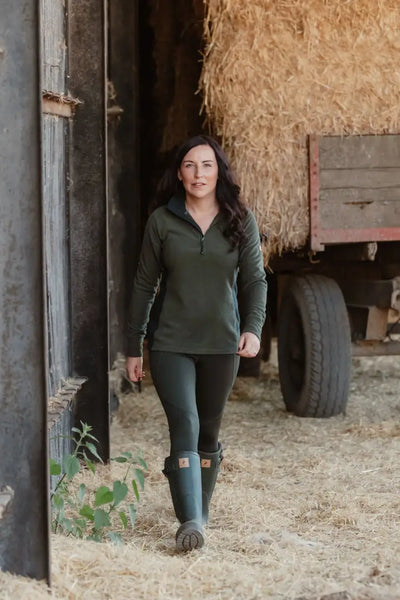 Woman in green trail fleece and boots for forest trail adventures