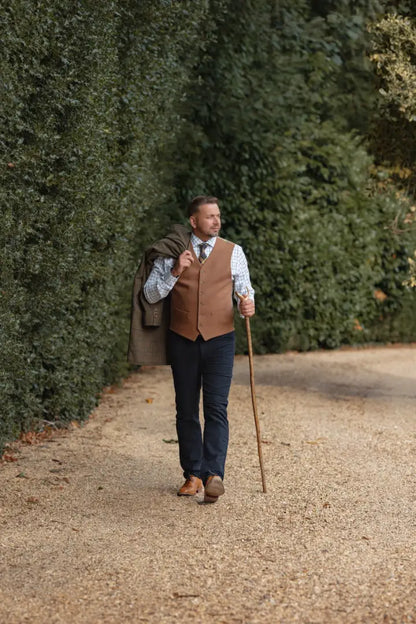 Man in forest moleskin jeans with vest and walking stick, stylish outdoor look