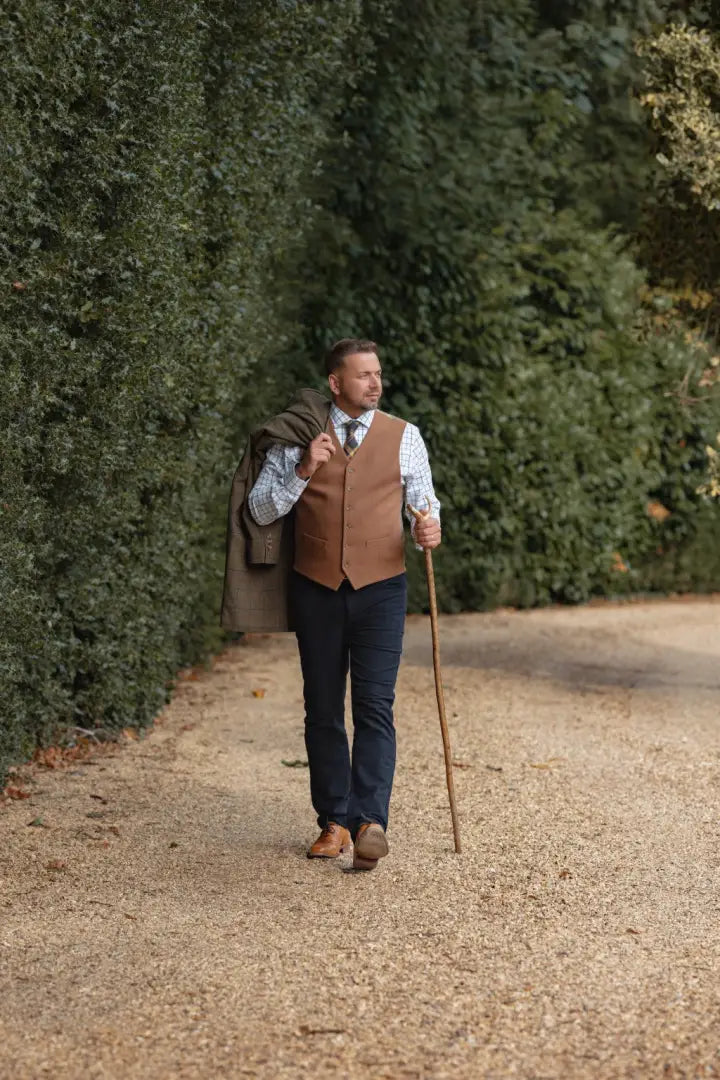 Man in forest moleskin jeans with vest and walking stick, stylish outdoor look