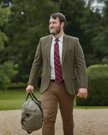 Man in green tweed jacket with duffel bag wearing New Forest Moleskin Jeans