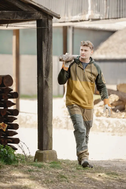Man carrying firewood in durable forest nightjar trousers perfect for outdoor life
