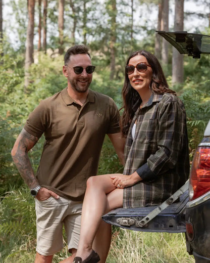 Couple posing by car trunk wearing stylish New Forest Pique Polo shirt in forest pique style