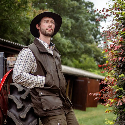 Man in a wide-brimmed hat models the New Forest Premium Tattersall Shirt outdoors