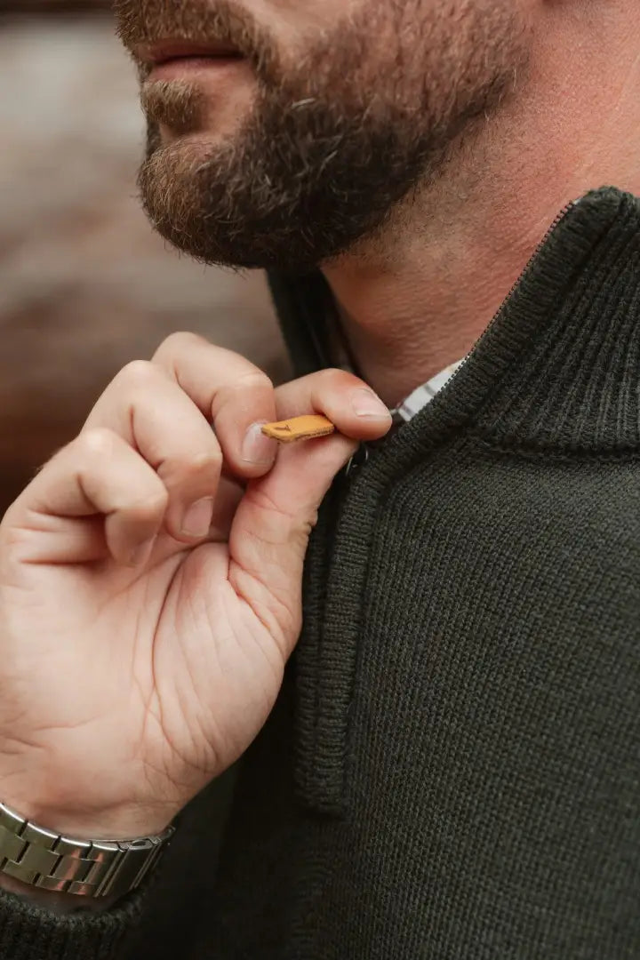 Man wearing New Forest Raven Zip Neck Jumper in dark green with leather zipper pull