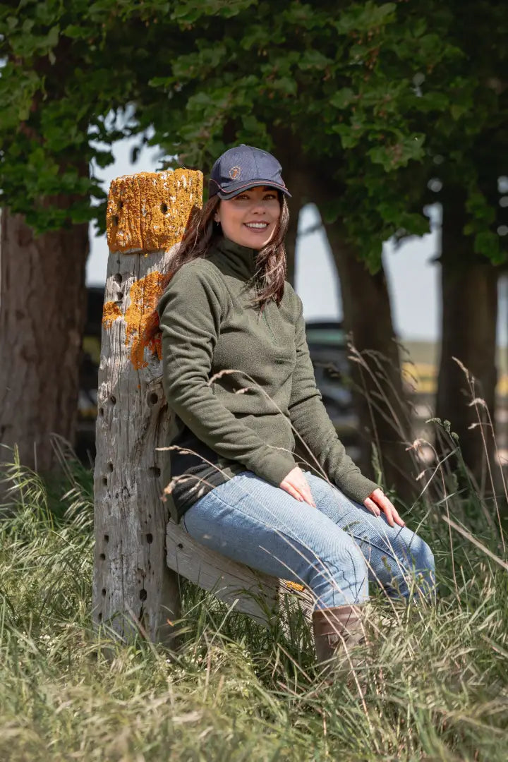 Woman in outdoor clothing wearing the New Forest Skeet Cap in a forest setting