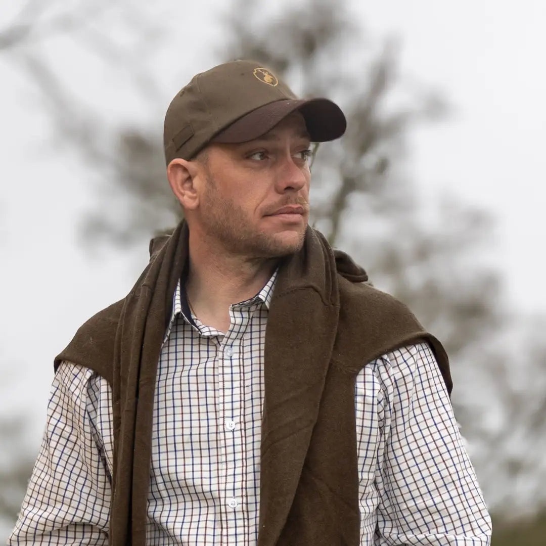 Man in a brown cap and checkered shirt models the New Forest Stag Baseball Cap