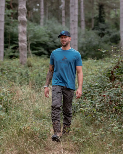 Man in blue New Forest Stag Logo T-Shirt with forest stag logo graphic casual wear