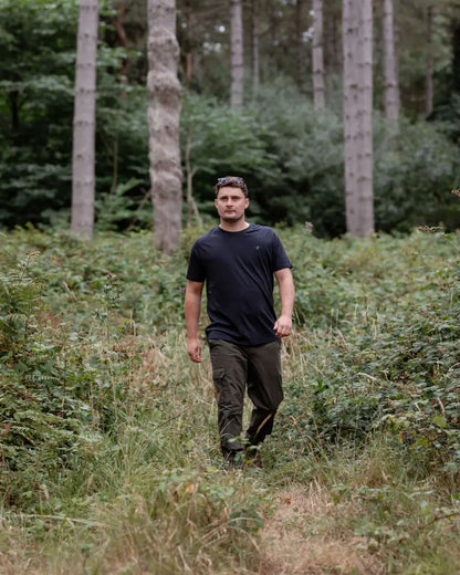 Man in dark clothing walking through woods on New Forest T-Shirt 2-Pack for perfect forest clothing