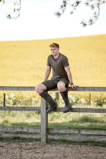 Man sitting on a fence wearing New Forest Trail Shorts perfect for forest trail adventures
