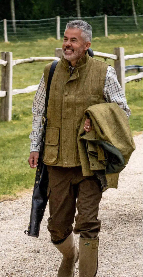 Two people in a luxurious tweed gilet stroll down a country path
