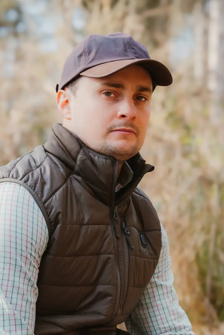 Man in a brown vest and cap rocking the New Forest Wax Baseball Cap style