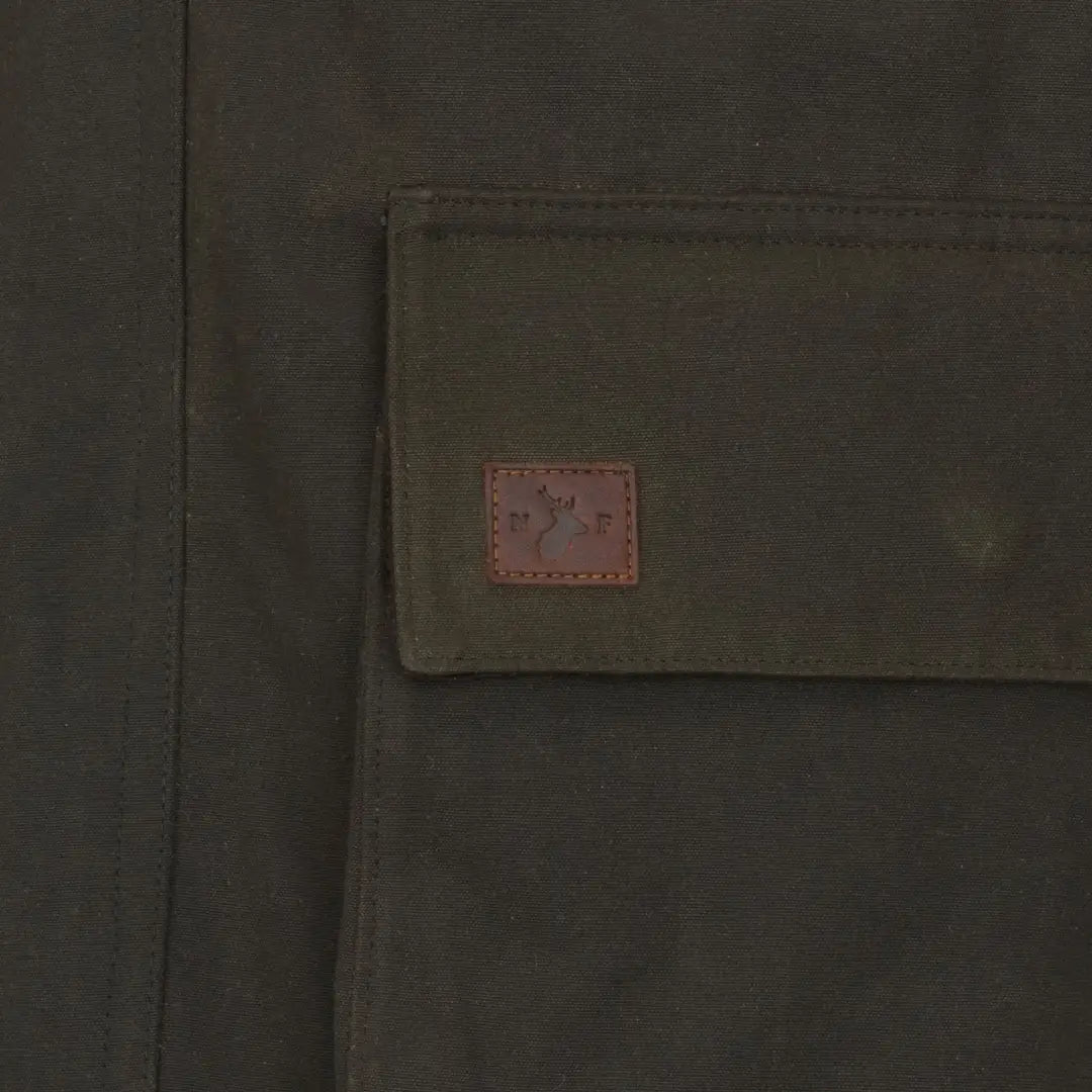 Olive green pocket with brown label on New Forest Woodsman Wax Jacket for forest woodsman style