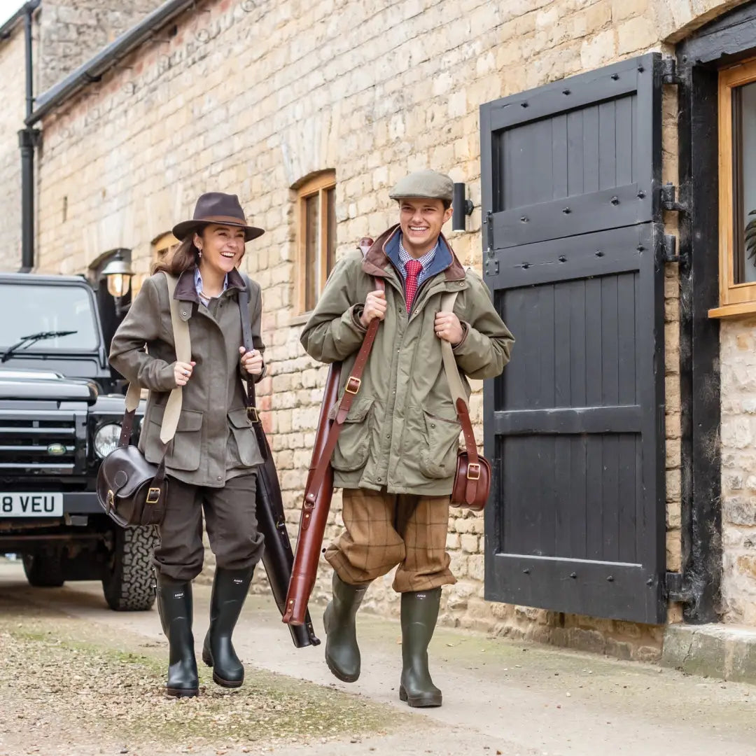 Two adventurers in boots and hats with a beautifully-crafted leather cartridge bag