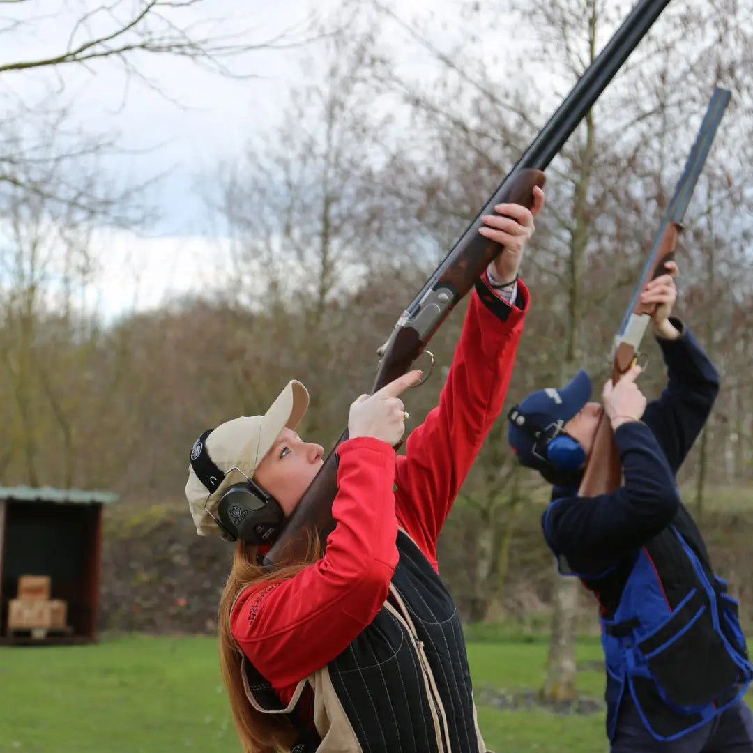 Two people in Percussion Skeet Vests aiming shotguns for clay pigeon shooting fun