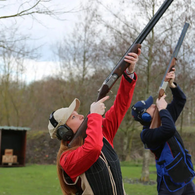 Two people enjoying clay pigeon shooting while wearing a Percussion Skeet Vest