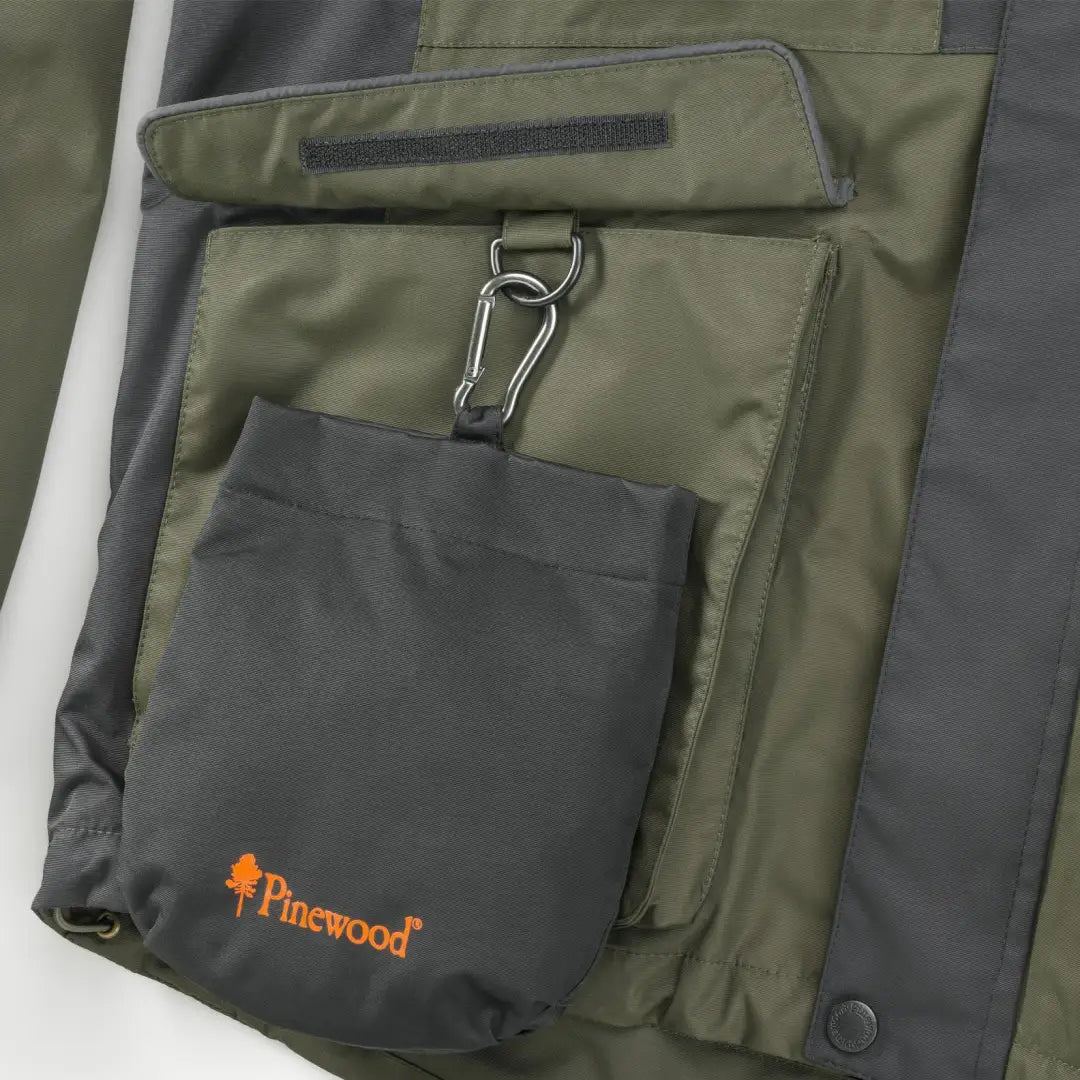 Green and gray jacket pocket with Pinewood Dog Sports Treat Bag for dog sports activities