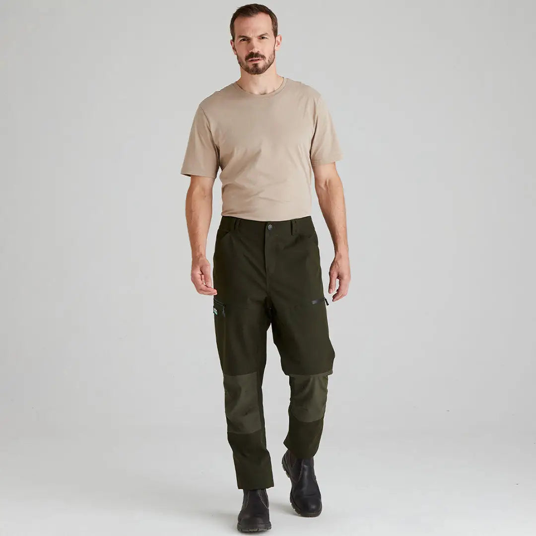 Man wearing green Ridgeline Cambrian Trousers and beige t-shirt perfect for all-day wear in worst weather