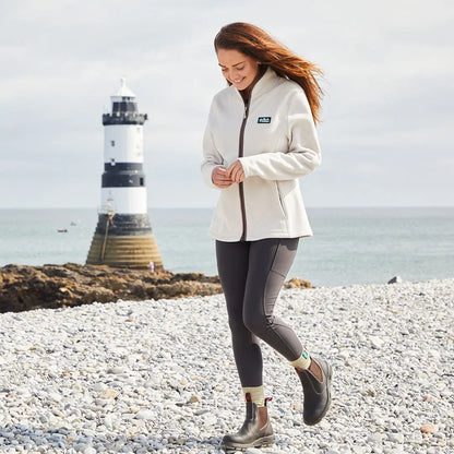 Woman wearing a cream-colored fleece jacket with Ridgeline Ladies Infinity Leggings