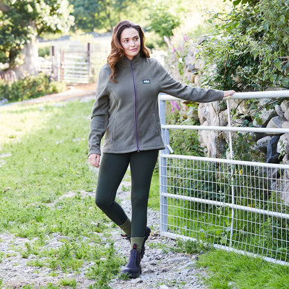Woman in olive green fleece jacket and leggings that provide versatility and a brushed finish