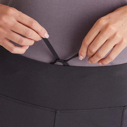 Person tying drawstring on Ridgeline Ladies Infinity Leggings showcasing mid-weight leggings feature