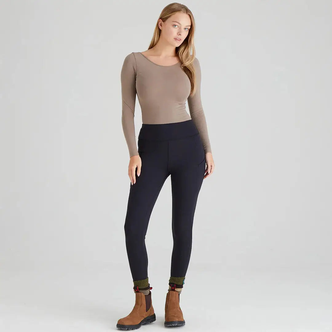 Woman wearing black infinity leggings and brown boots in country clothing style