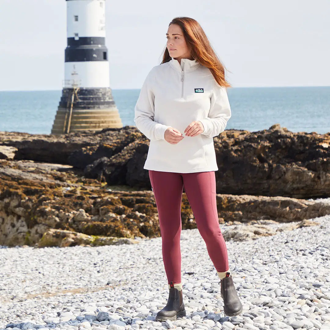 Woman in cream pullover and maroon infinity leggings for stylish athletic wear or country clothing