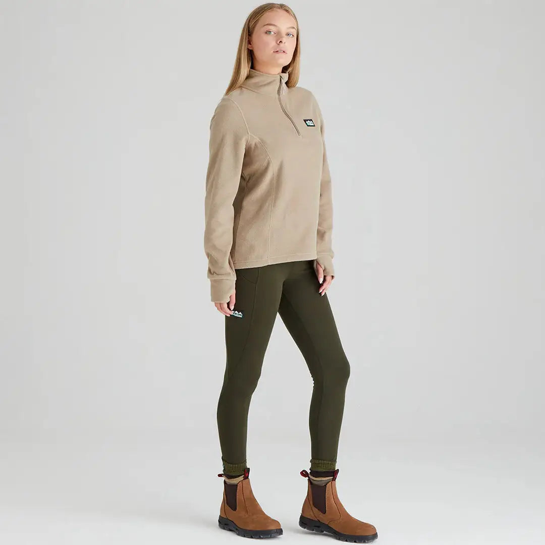 Woman in beige Ridgeline Ladies Narvik Fleece with green leggings and brown boots