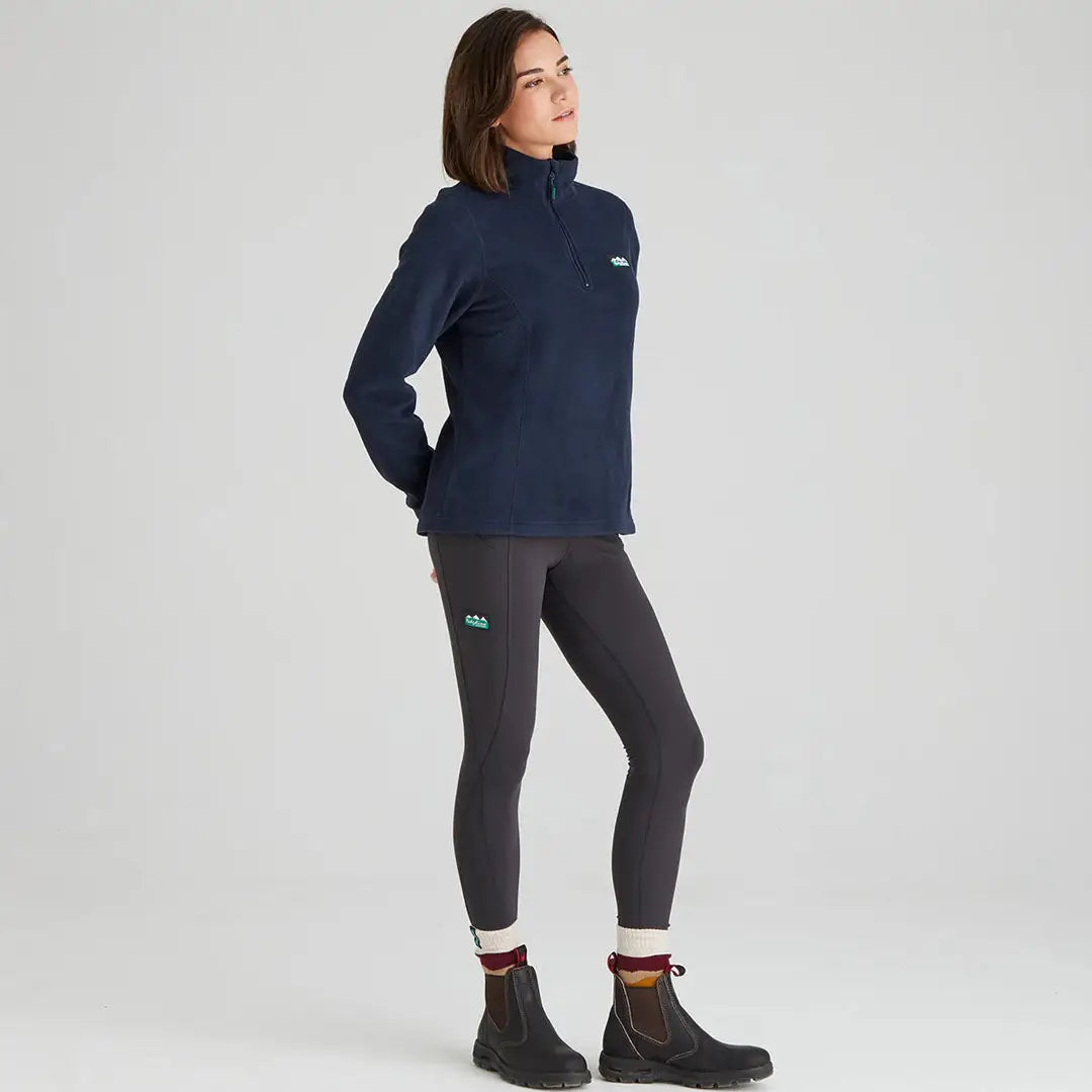 Woman in navy Ridgeline Ladies Narvik Fleece with gray leggings and black boots
