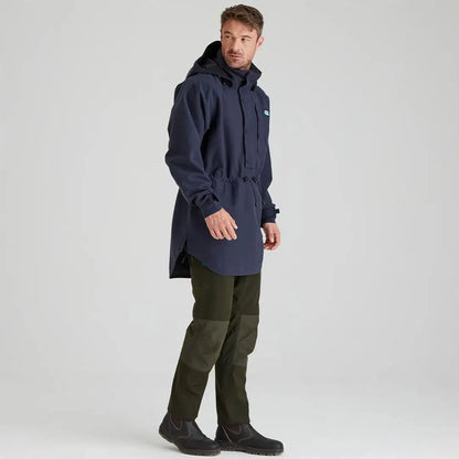 Man wearing Ridgeline Monsoon Classic Smock and green pants in a navy hooded poncho