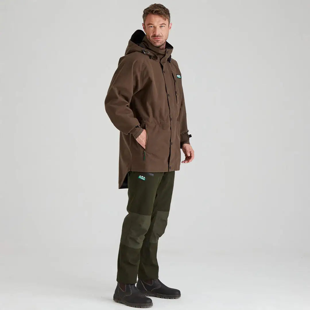 Man wearing Ridgeline Mens Monsoon Classic Waterproof Jacket and green pants in outdoors