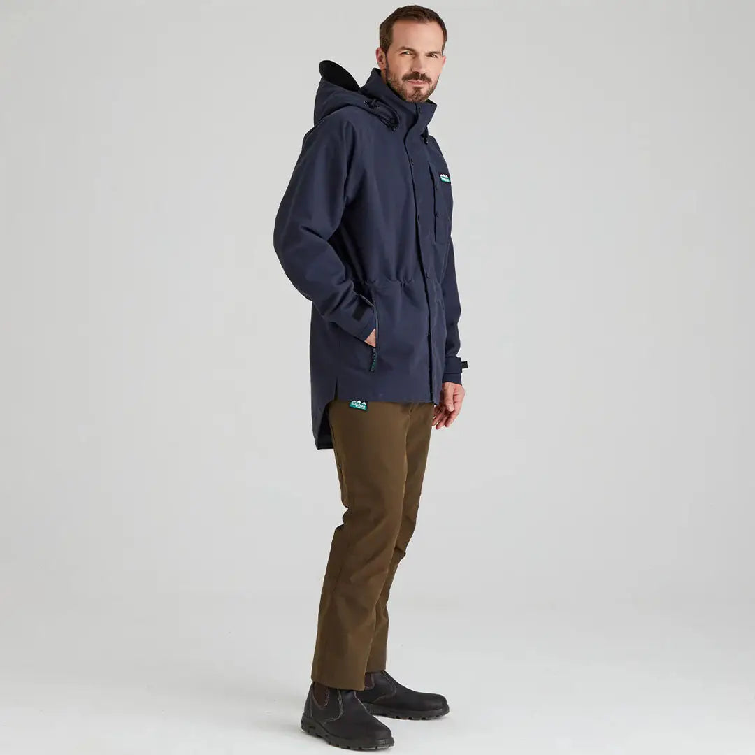 Man in navy Ridgeline Monsoon Classic Waterproof Jacket with brown pants