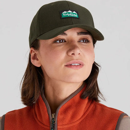 Woman wearing Ridgeline Monsoon Classic Cap with patch and orange fleece vest