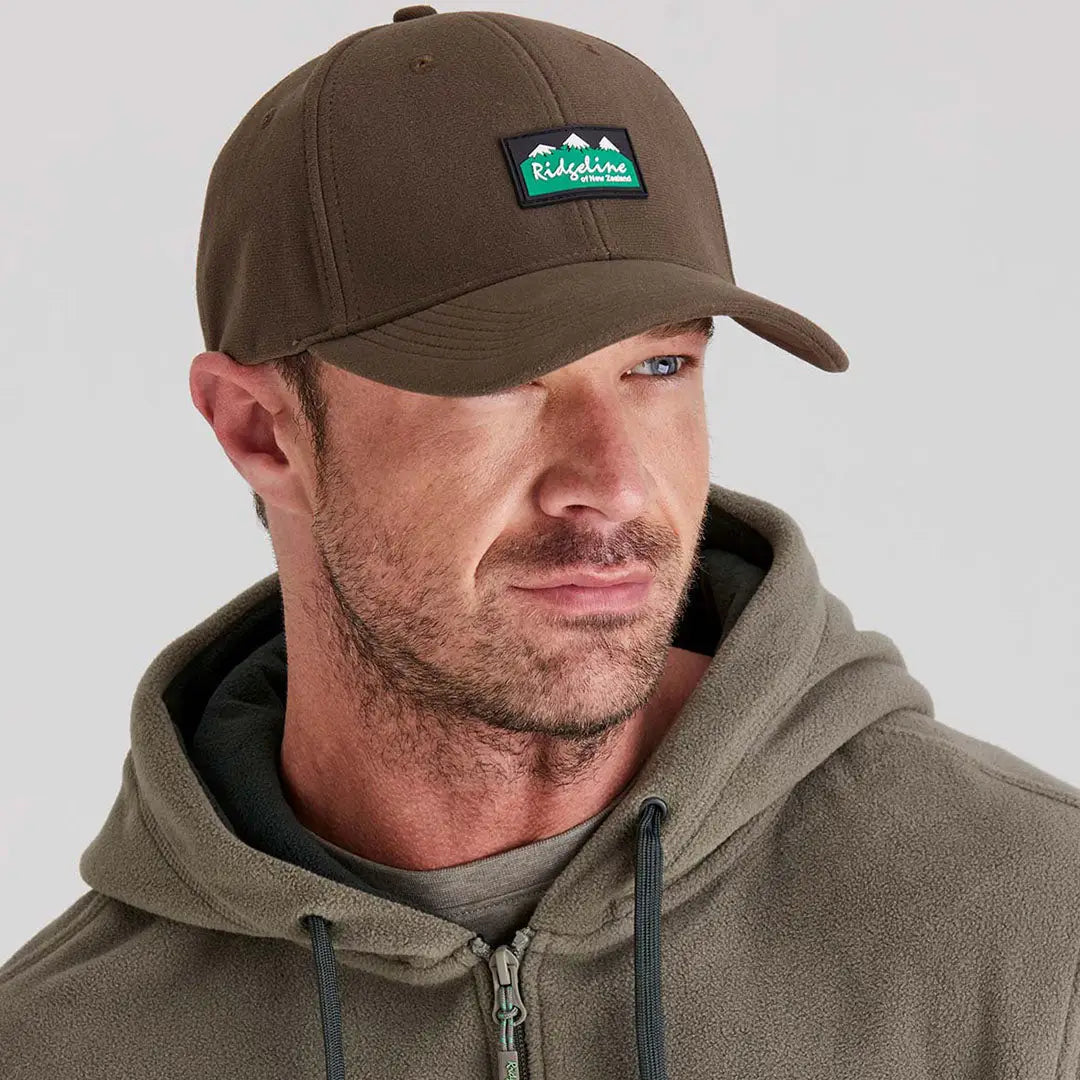 Man wearing Ridgeline Monsoon Classic Cap with mountain logo and fleece hoodie