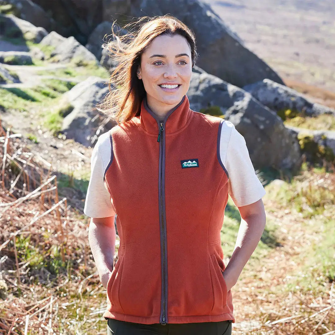 Woman wearing rust-colored fleece vest from Ridgeline Womens Kodiak Gilet, exceptionally advanced southern style