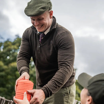 Smiling man holding clay targets wearing Seeland Benjamin Half Zip Fleece for outdoor fun