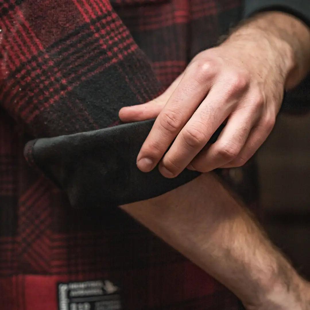 Red and black plaid Yukon shirt sleeve rolled up, perfect for Canada Yukon adventures