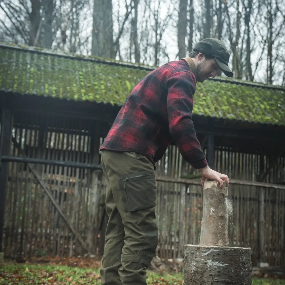 Man in plaid shirt splitting wood wearing the Seeland Canada Yukon Shirt outdoors