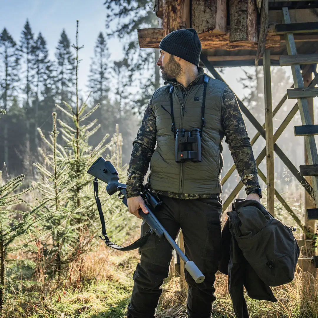 Hunter with rifle and binoculars wearing Seeland Celsius Heat Liner Waistcoat for warmth