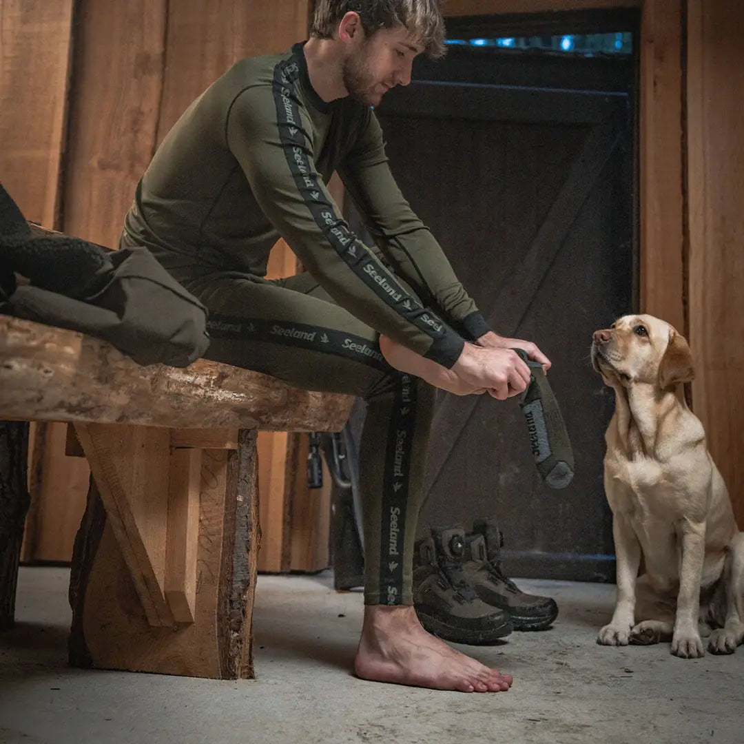 Man putting on Seeland Field Thermo Sock for all-day warmth and comfort