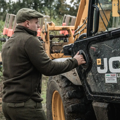 Man fueling construction gear wearing Seeland Fog Fleece Jacket, perfect for country clothing and hunting