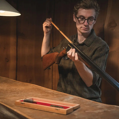 Man cleaning a shotgun wearing Seeland Glen Flannel Shirt outdoors