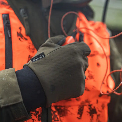 Gloved hand holding Seeland target gloves, perfect for hunting country clothing