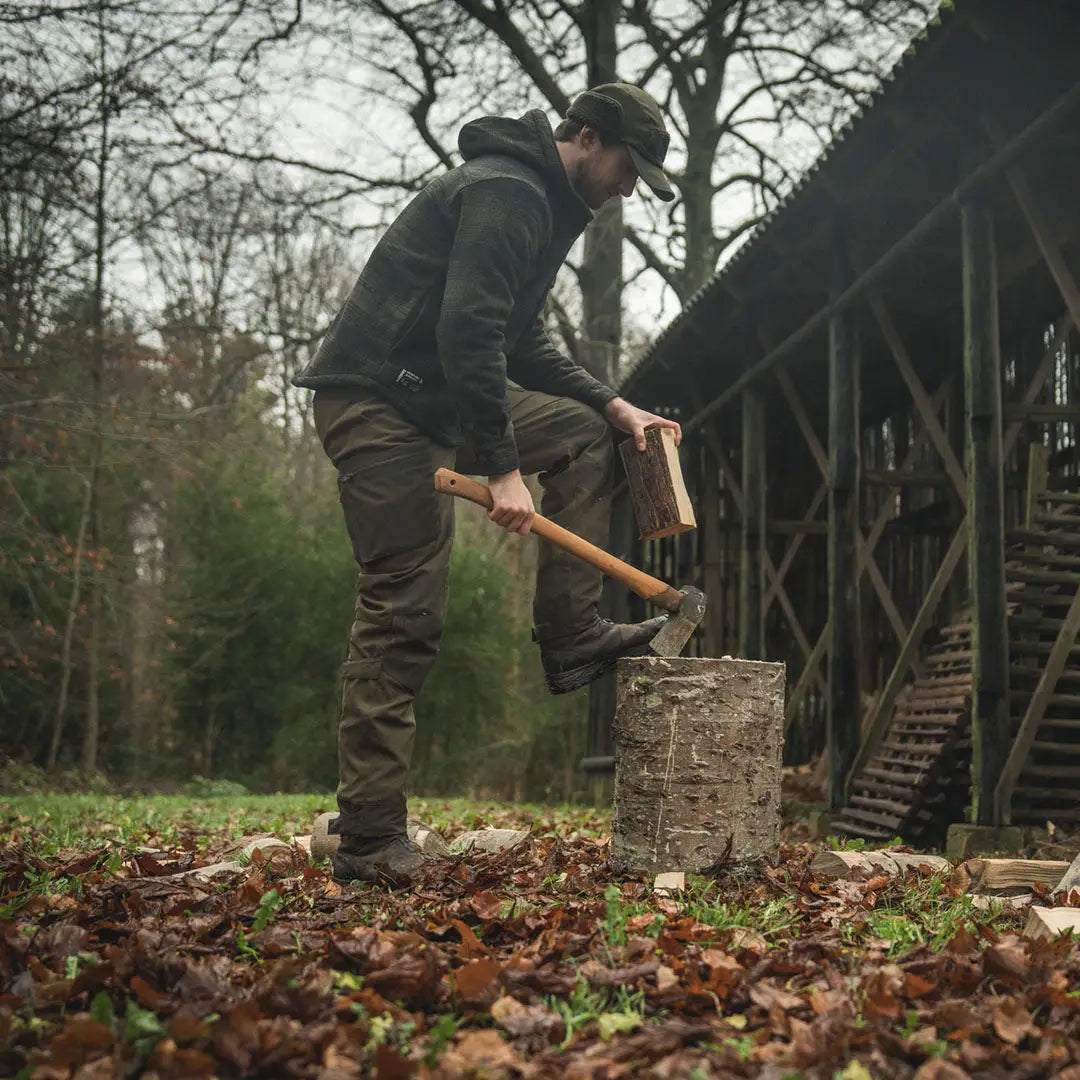 Man splitting wood wearing a Seeland Teddy Fold Down Cap, perfect fold-down cap style