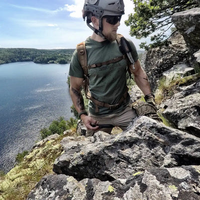 Rock climber in Snugpak T-Shirt, ready for the outdoors by a lake cliff