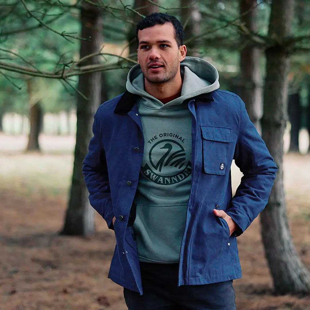 Man wearing a blue jacket over a green hoodie in Swanndri Barrytown V3 Canvas Jacket