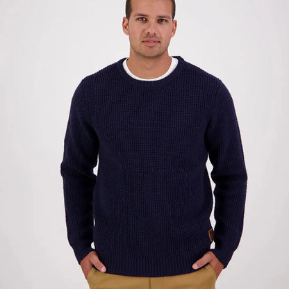 Man wearing Swanndri Fistral Waffle Knit navy blue crew neck sweater and tan pants